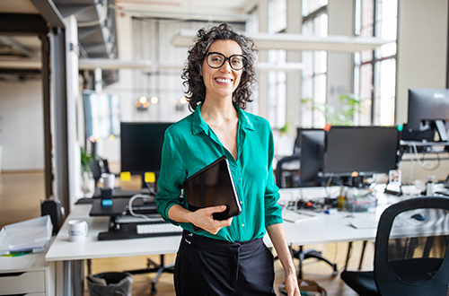 Image of woman holding paperwork in office