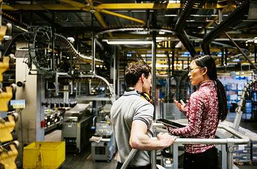 Image of two people in factory discussing work