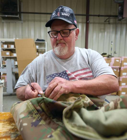 Man working on military attire.