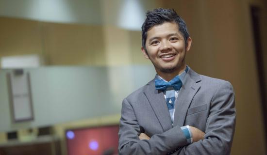 Man in suit smiling with crossed arms