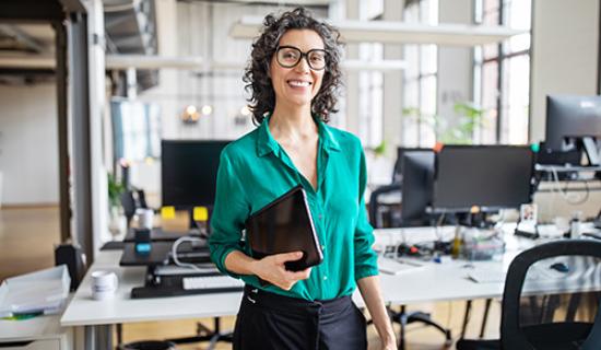 Image of woman holding paperwork in office