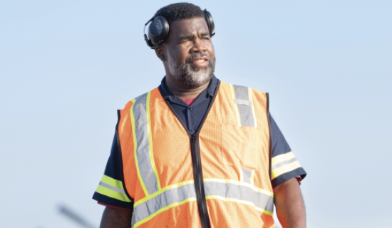 Man in orange construction vest with headphones